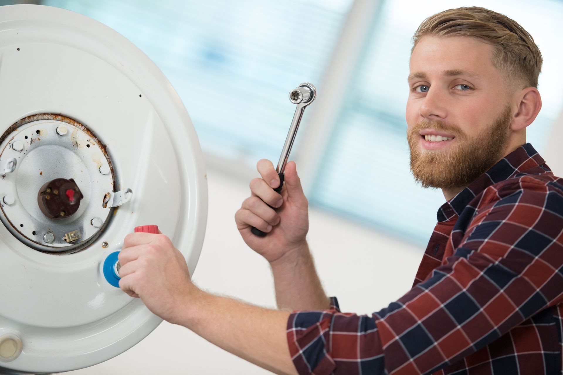 smiling technician repairing an hot-water heater smiling technician repairing an hot-water heater